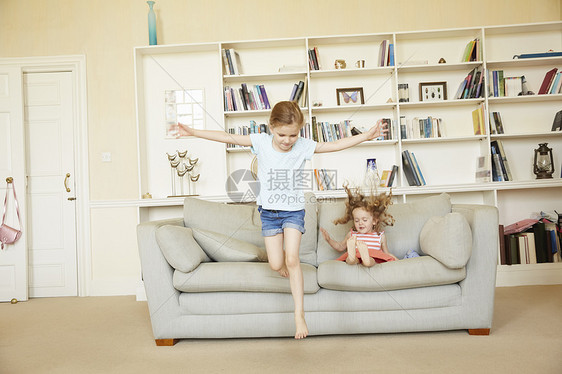 两个年轻姐妹从沙发上跳下图片
