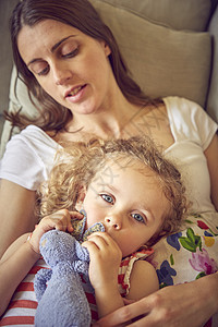 孕妇和女儿靠在沙发上用柔软的玩具靠在沙发上图片