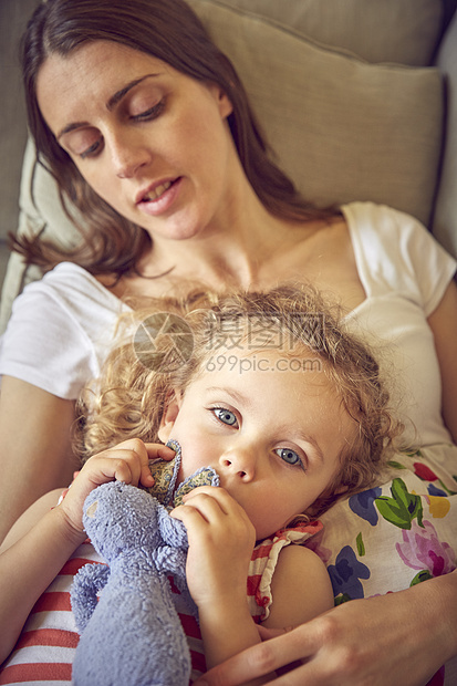孕妇和女儿靠在沙发上用柔软的玩具靠在沙发上图片