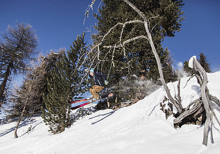 滑雪运动员滑雪下山空中跳跃图片