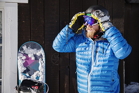 穿滑雪服调整护目镜滑雪板的人图片