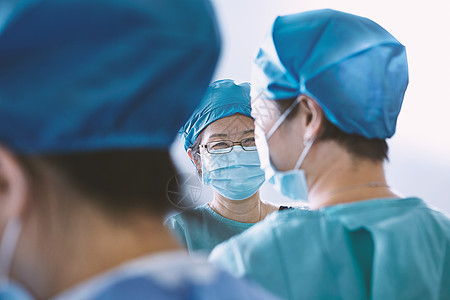 身穿防护服在产科手术室讨论的外科医生图片
