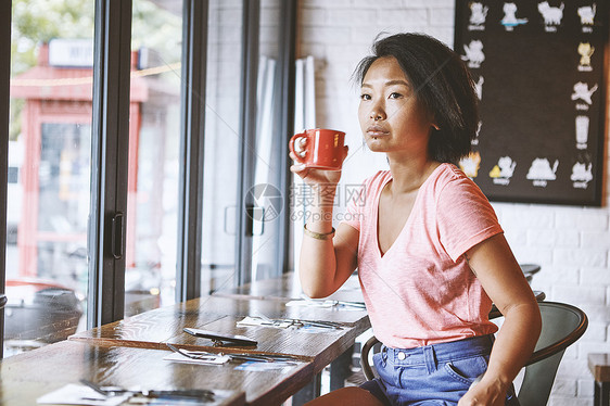 年轻妇女在靠窗的座位上观看图片