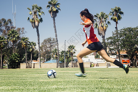 女学生在学校运动场上踢足球图片