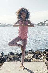 湖边做瑜伽树姿势的女学生图片