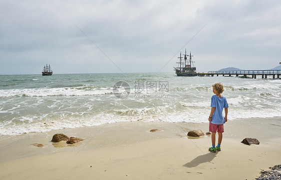 海滩上的男孩看着海上的船只弗洛里亚诺波利斯圣卡塔琳娜巴西南美图片