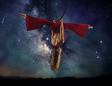 红色夜空年轻女空中杂技演员从事分裂倒吊挂从圈挤奶方式背景背景