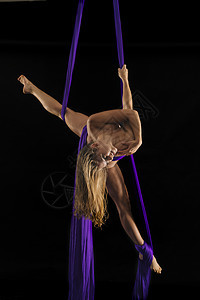 裸露的年轻女空中杂技表演被黑底的丝绳缠着躯体图片