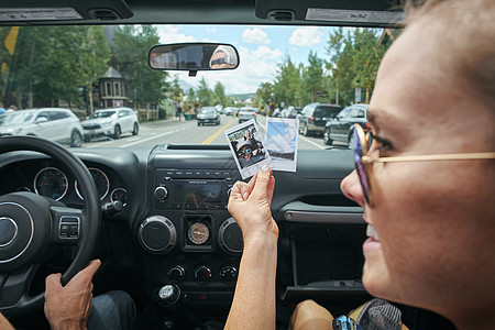 美国科罗拉多州布雷肯里奇一名年轻女子手持即时照片在公路旅行中的特写镜头图片
