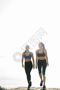 两名年轻妇女接受培训在海滩上行走图片