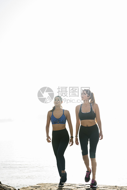 两名年轻妇女接受培训在海滩上行走图片