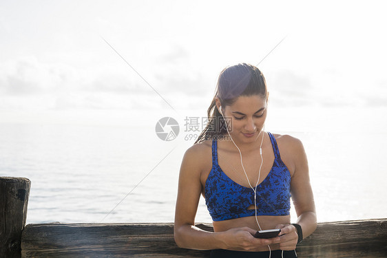 青年妇女海滨培训选择智能手机音乐图片