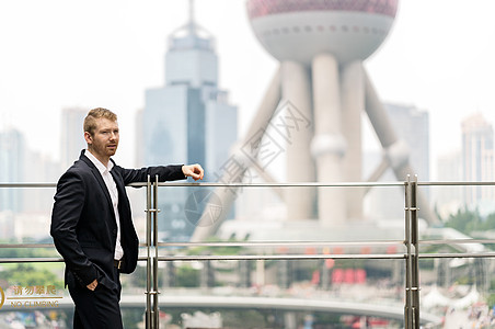 上海金融中心手搭在扶手上的青年商人图片