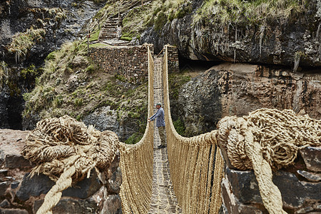 在秘鲁库斯科悬索桥上的男游客图片