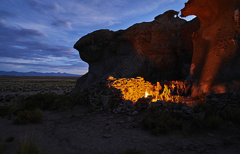 母亲和儿子点着火在黄昏的山洞里奥鲁罗玻利维亚南美图片