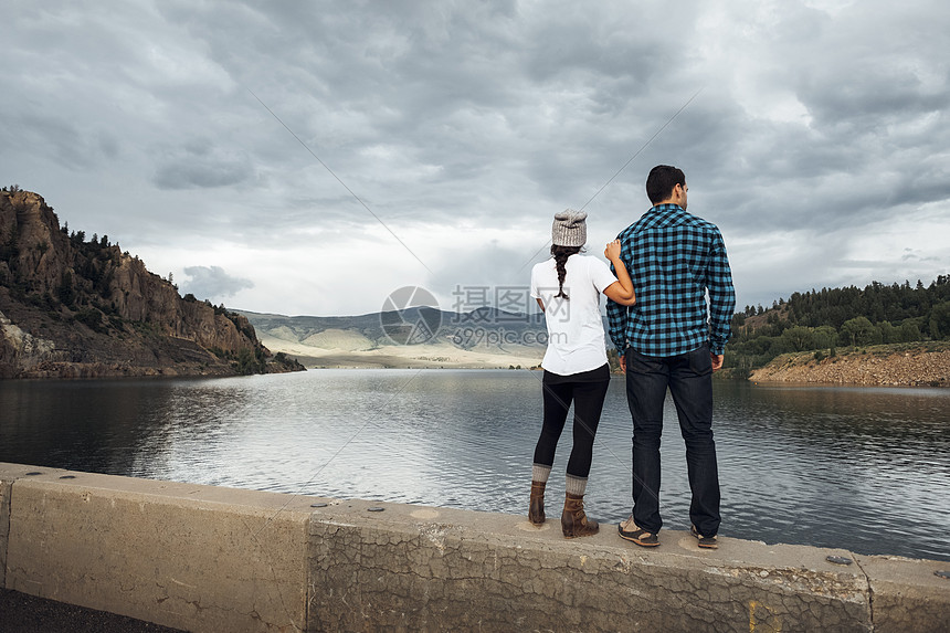 站在湖边的墙上观景的夫妇美国科罗拉多州图片