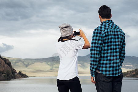 男人看着在湖边拍摄照片的女人银角美国科罗拉多州图片
