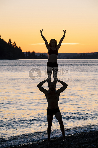 日落时在海滩上做瑜伽的情侣图片