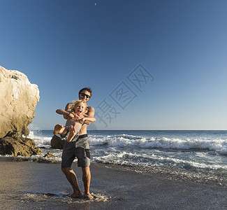 哥哥抱着弟弟大笑美国马里布塔多尔海滩图片