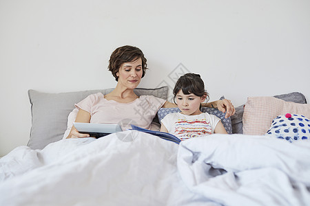 母亲和女儿在床上看书图片