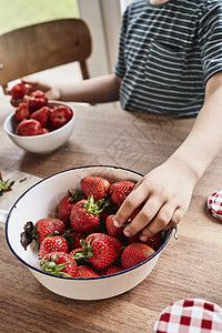 小男孩从碗里拿草莓图片