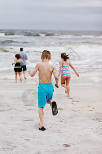 美国阿拉巴马州道芬岛从海滩后视向边奔的人类和儿童图片