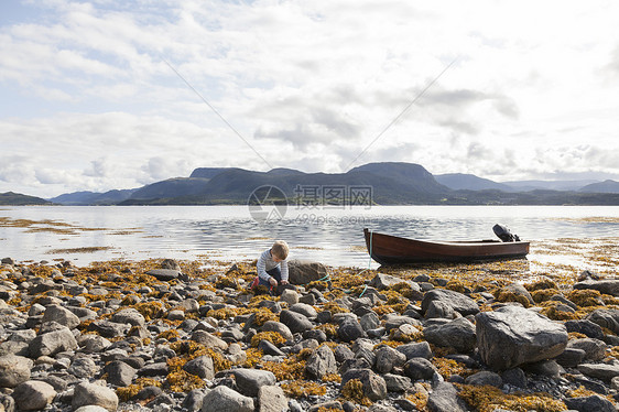 在石头中间玩耍的男孩在挪威福德奥雷罗姆斯达尔图片