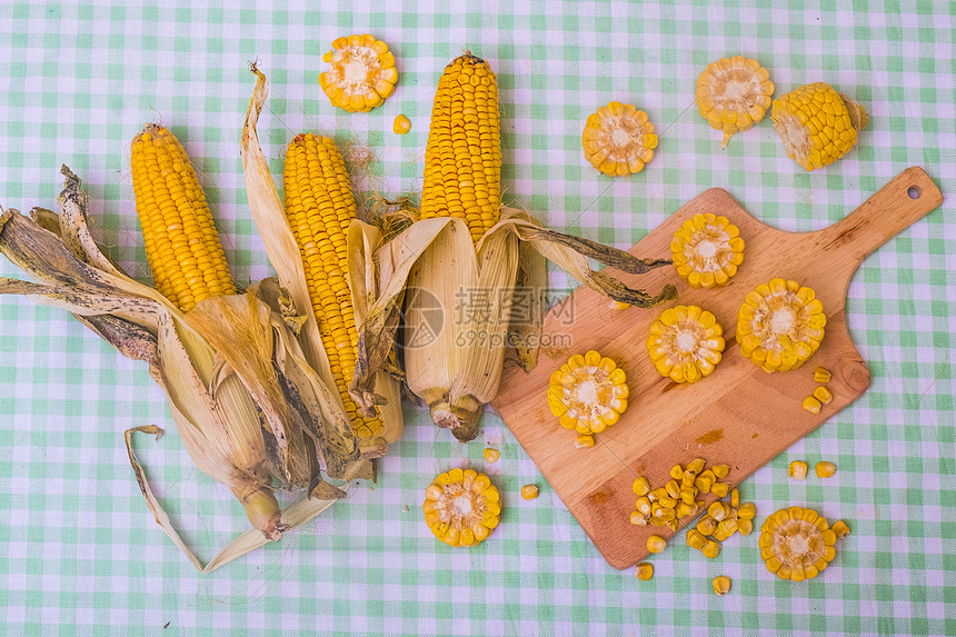 砧板上切开的玉米和整个的玉米图片