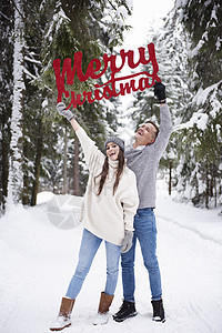 有圣诞快乐的年轻夫妇在雪中说着圣诞快乐的话图片