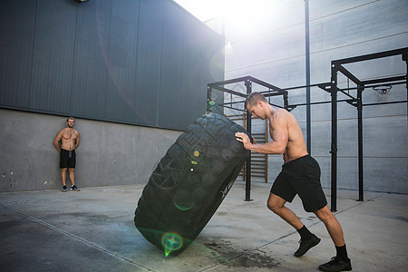 男子在健身房锻炼举重轮胎图片