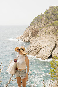 一名妇女沿着海岸线看风景图片