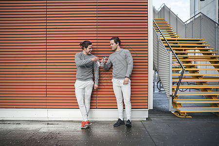 年轻男双胞胎在城市中碰手庆祝图片