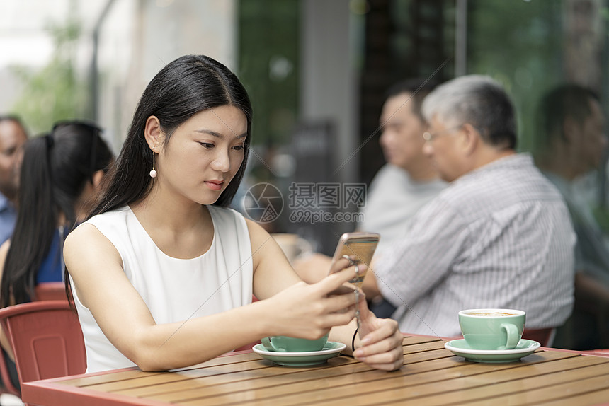 女商人在户外咖啡店用手机图片