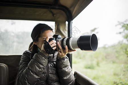 南非克鲁格公园巡游卡车上年轻女游客拍摄照片图片