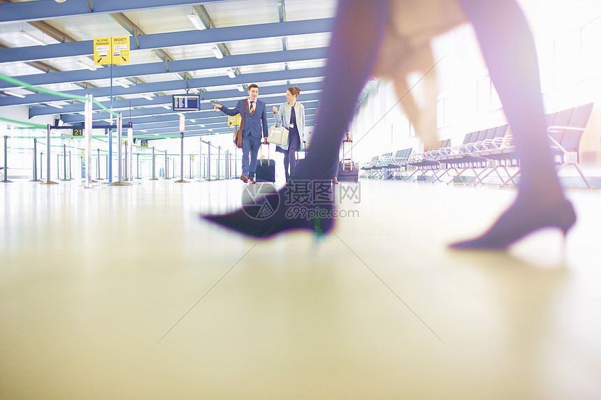 商人团队携带轮式手提箱通过机场图片