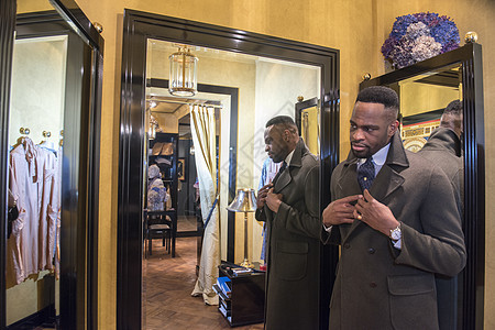 在传统裁缝店照镜子的年轻男客户图片