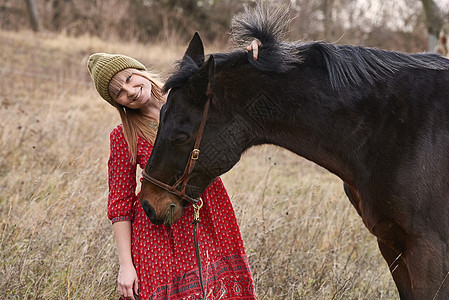 在野外牵着马带着笑容的女人肖像图片