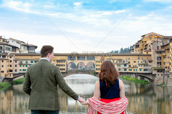 一对年轻夫妇手拉手看着庞特韦奇奥旧桥图片