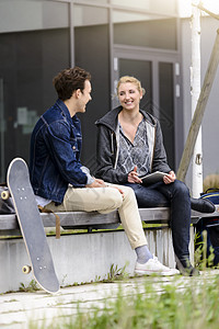在大学教室外石阶上聊天的男女青年学生图片