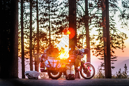 美国加利福尼亚州公园日落时停在森林路边的摩托车图片