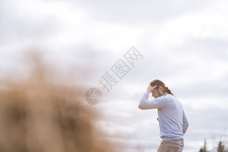 花园里的男人用手摸着头图片