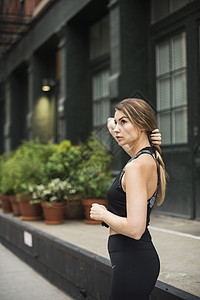 身穿运动服的妇女抓着头发远望美国纽约图片