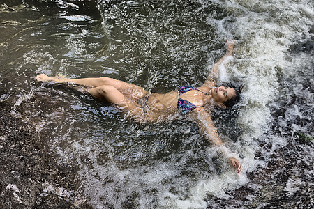 妇女躺在溪流中图片
