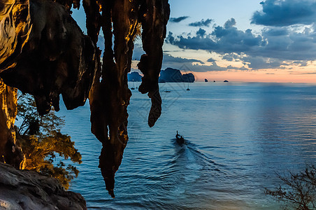 日落时水里的船和垂落的树叶泰国克拉比通赛图片