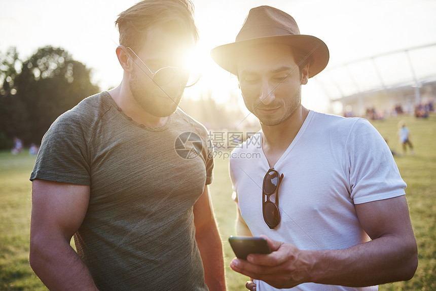两个年轻人在音乐节看手机图片