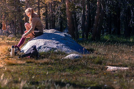 坐在美国加利福尼亚州约塞米特公园岩石上的女人图片