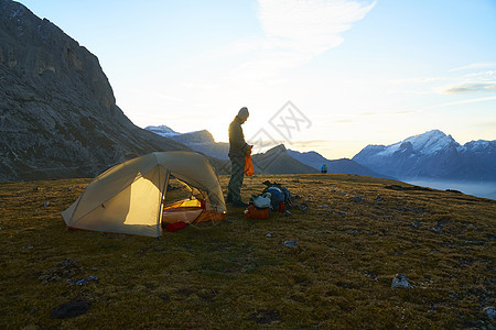 日落时在帐篷旁边站着的登山者意大利卡纳泽特伦蒂诺阿尔托迪格图片
