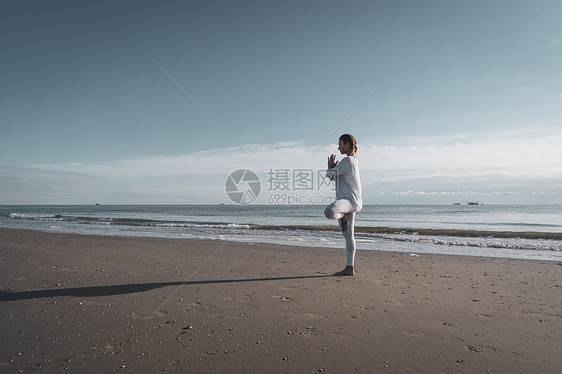 妇女在海滩上做瑜伽图片
