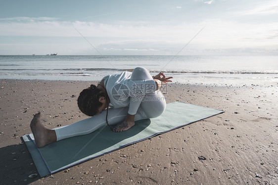 妇女在海滩上做瑜伽图片