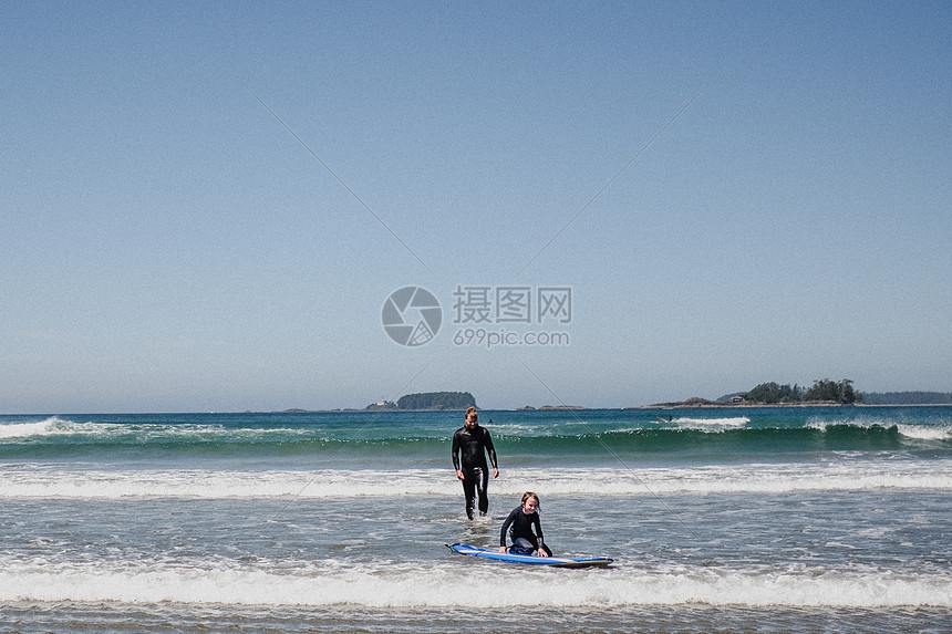 父亲和女儿在加拿大托菲诺海滩上冲浪图片